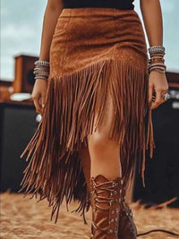 Asymmetrical Fringe Skirt featuring tan fringe design, worn with bohemian accessories in outdoor setting.