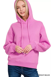 Zenana Drawstring Relaxed Fit Fleece Hoodie in Bright Mauve worn by a smiling woman.