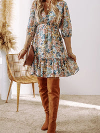 Floral Print Ruffle Hem Mini Dress worn by a model with knee-high boots in a stylish indoor setting.