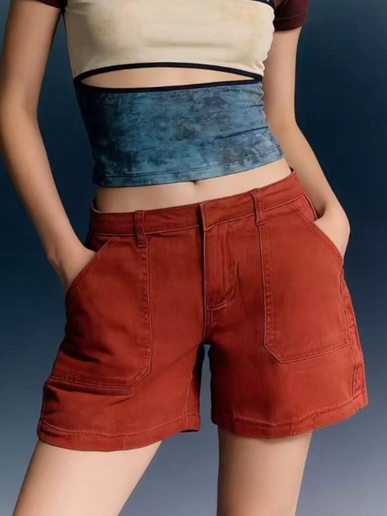 Model wearing Pocketed Denim Shorts in orange, showcasing side pockets and a fitted top.