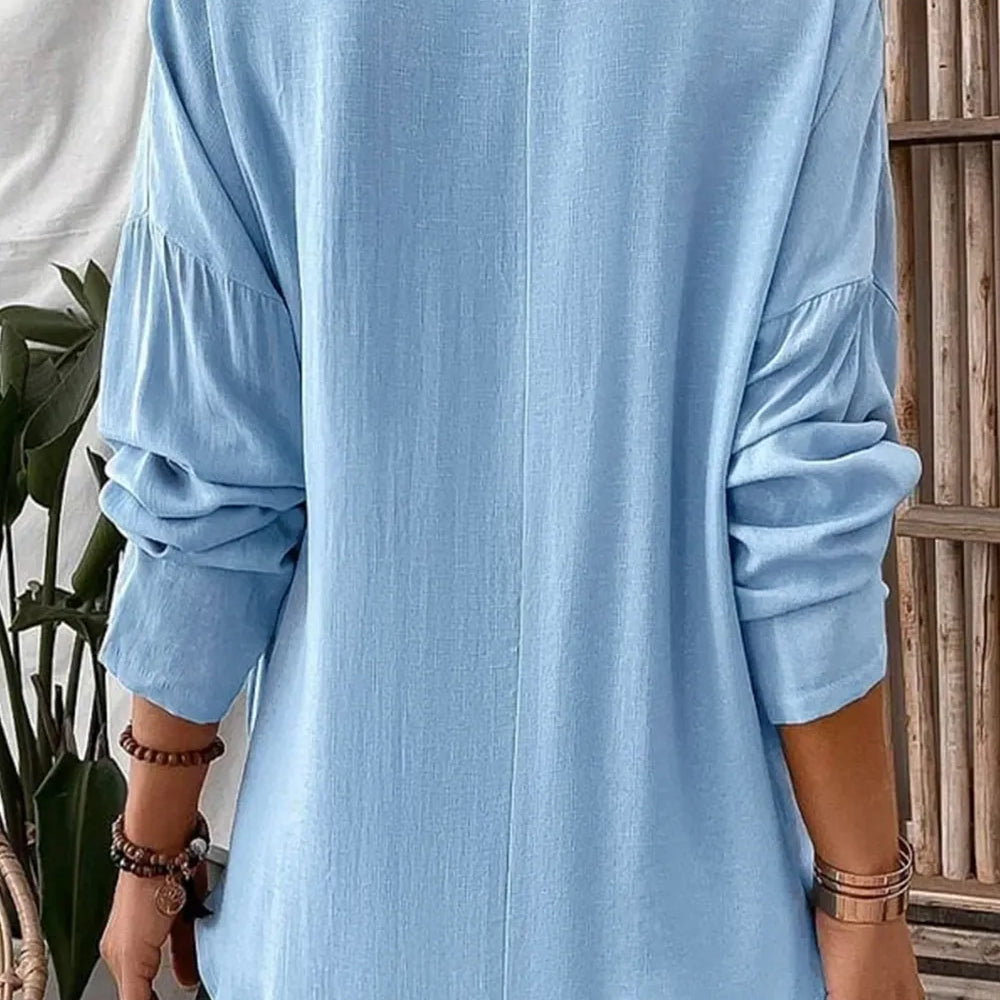 Back view of a woman wearing a Solid Color Notched Long Sleeve Blouse in light blue with long sleeves.