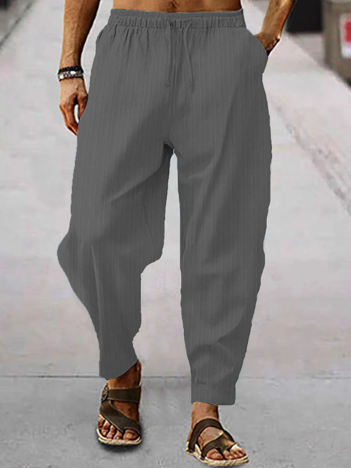 Men's full size drawstring pants with pockets plus size in gray walking outdoors.