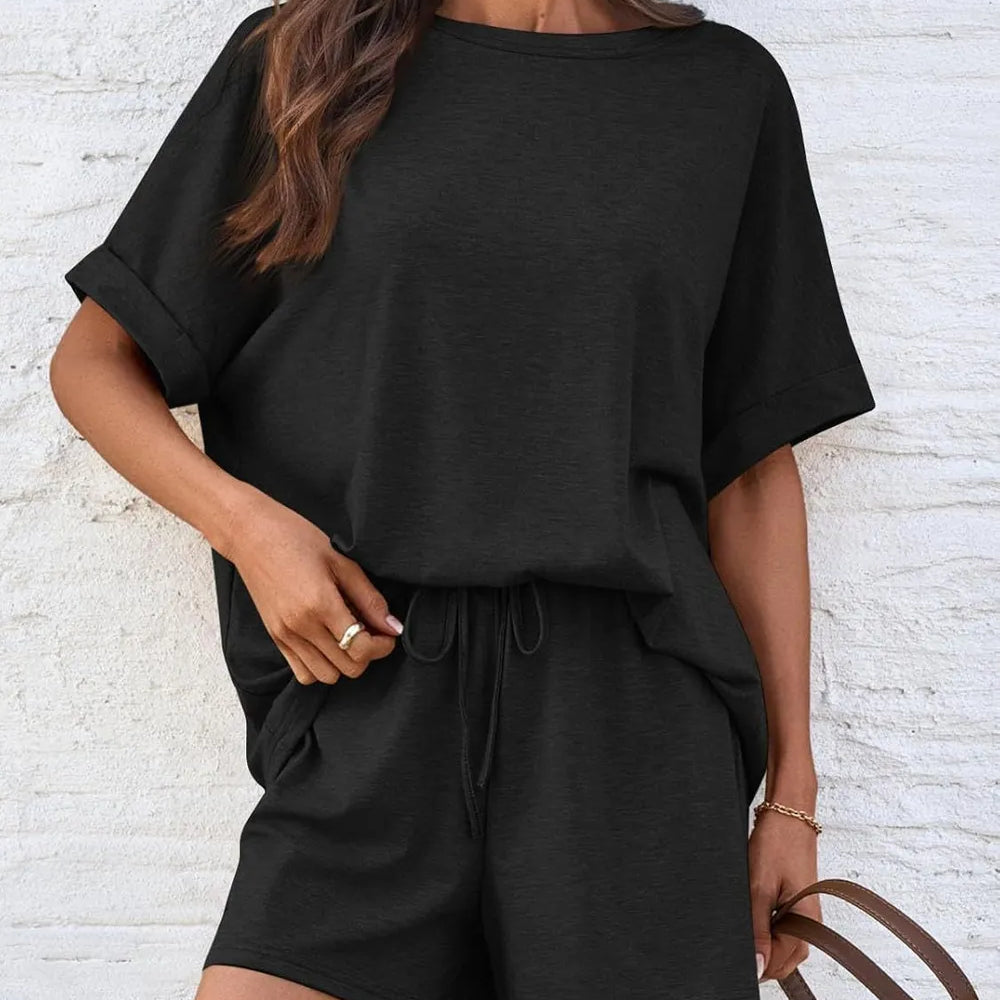 Round Neck T-Shirt and Drawstring Shorts Set featuring a model in a stylish black outfit against a textured background.
