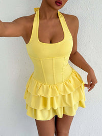 Yellow halter neck ruffle mini dress with layered skirt and corset-style paneling