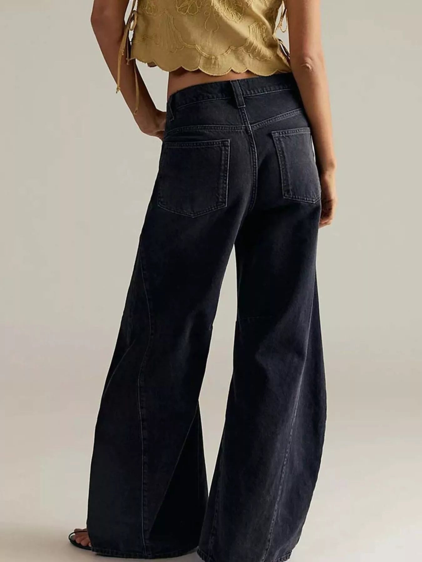 Model wearing Washed Wide Leg Jeans from the back, showcasing the wide-leg style and pocket details.