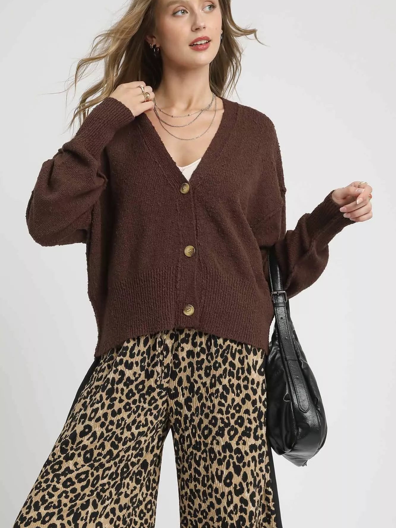 Umgee Button-Front V-Neck Knit Cardigan styled with leopard print pants and a bag, showcasing a chic layered look.