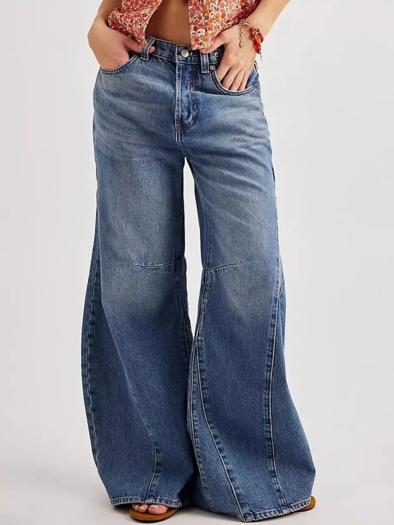 Washed Wide Leg Jeans displayed on a model with a floral top, featuring a wide leg design and light blue wash.