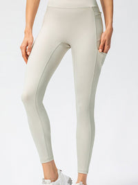 Full Size Slim Fit High Waist Long Sports Pants with Pockets in light color, featuring a high waist and side pockets.