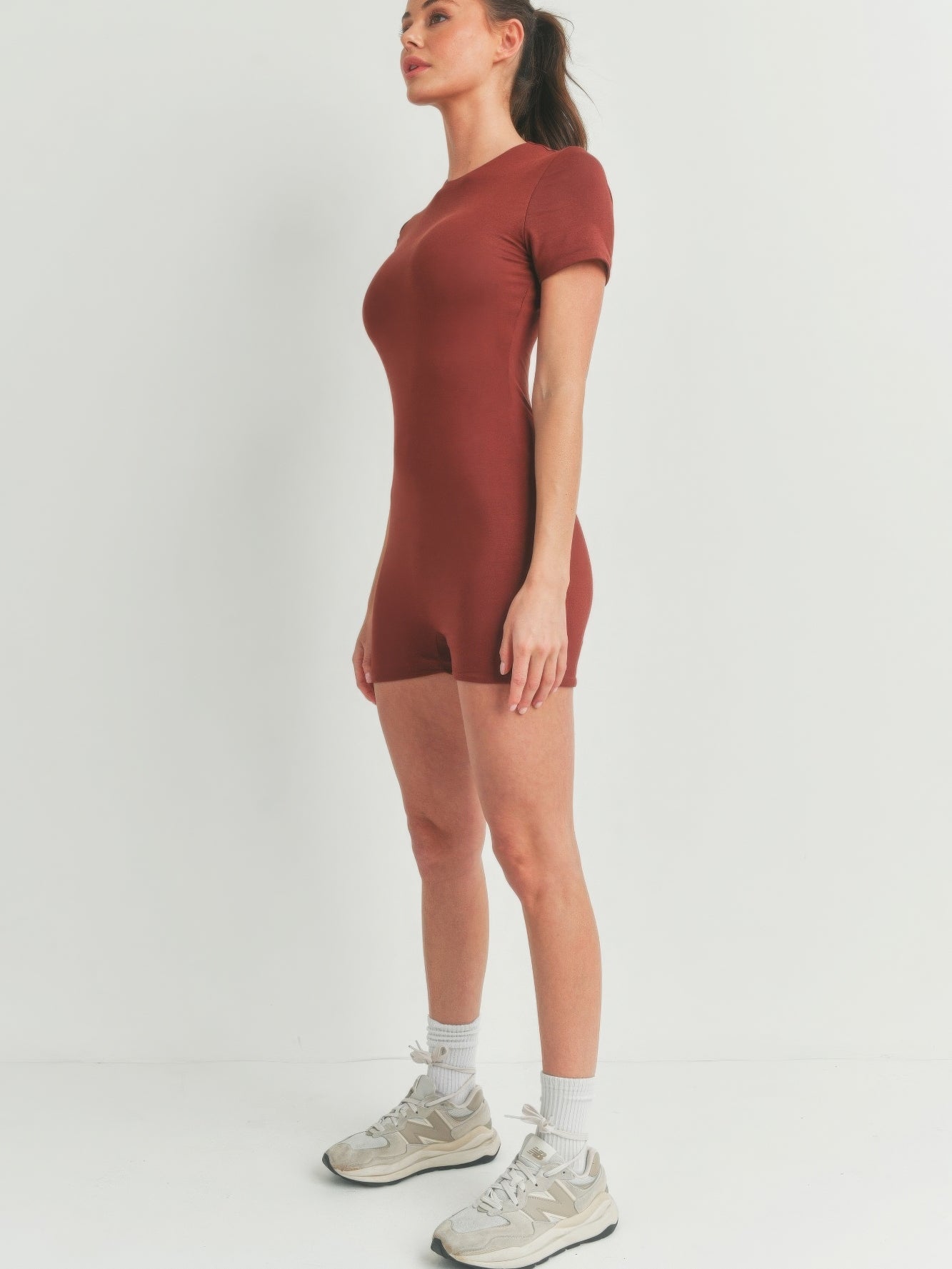 Model wearing a Solid Color Bodycon Jumpsuit in brown, showcasing its flattering fit and stylish design.