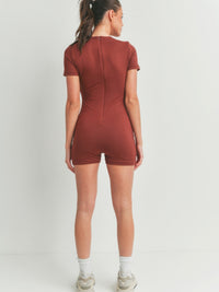 Model showcasing the back view of a Solid Color Bodycon Jumpsuit in brown, highlighting its flattering fit.