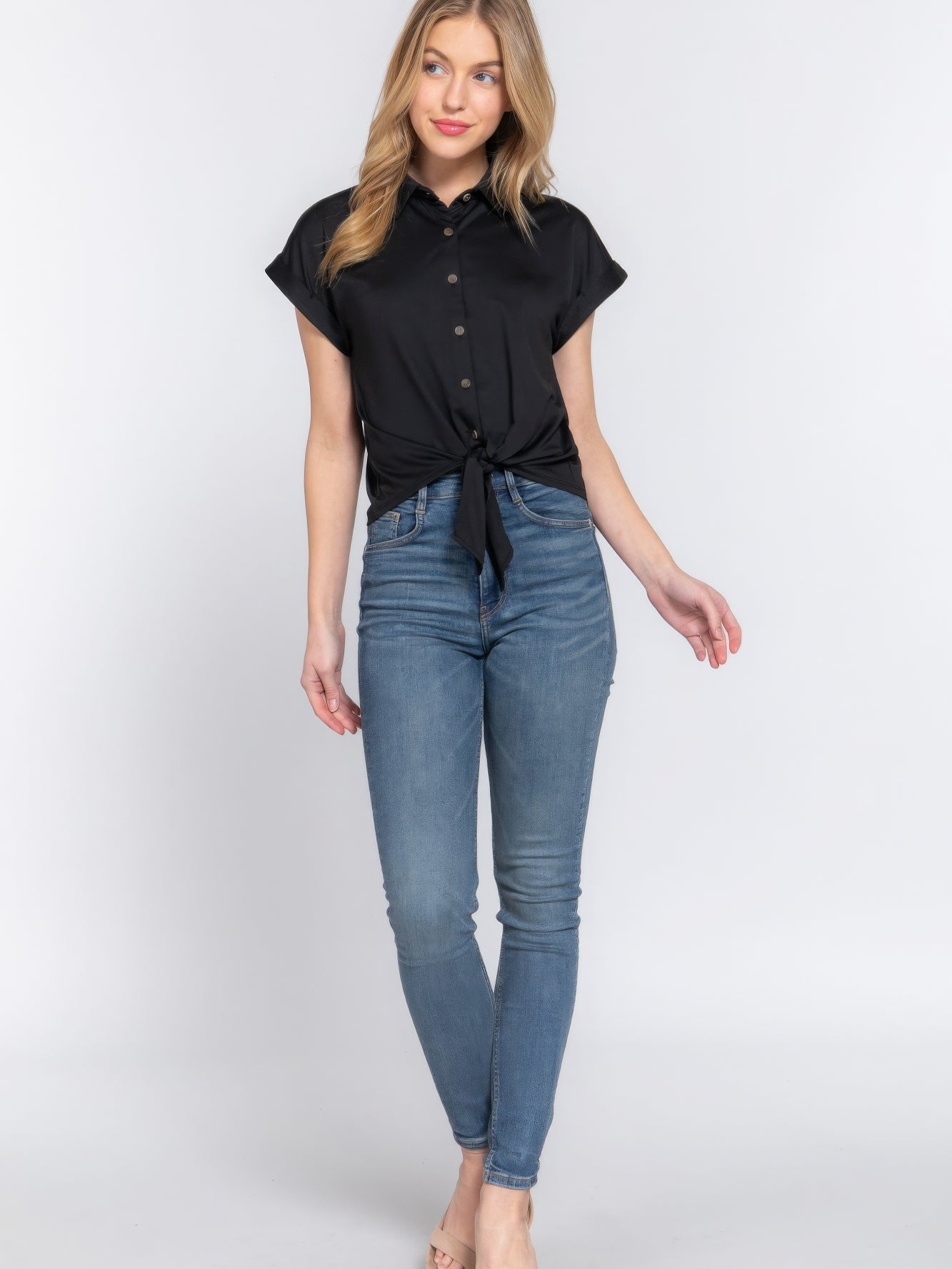 Short Slv Front Tie Stretch ITY Top worn with blue skinny jeans, featuring a chic front tie detail and a stylish button-up design.