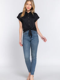 Short Slv Front Tie Stretch ITY Top worn with blue skinny jeans, featuring a chic front tie detail and a stylish button-up design.