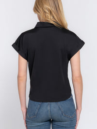 Back view of a woman wearing a Short Slv Front Tie Stretch ITY Top, showcasing its smooth fabric and stylish design.