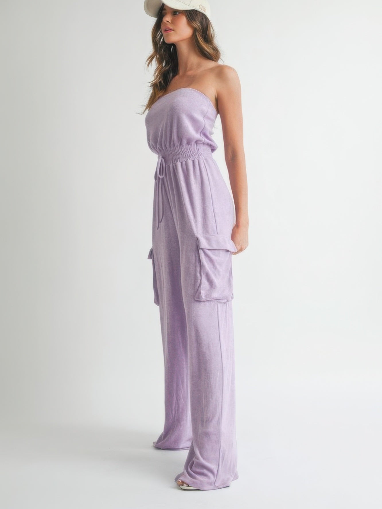 Woman wearing a Tube Top Jumpsuit Romper in lavender with pockets and a cap, showcasing effortless summer style.