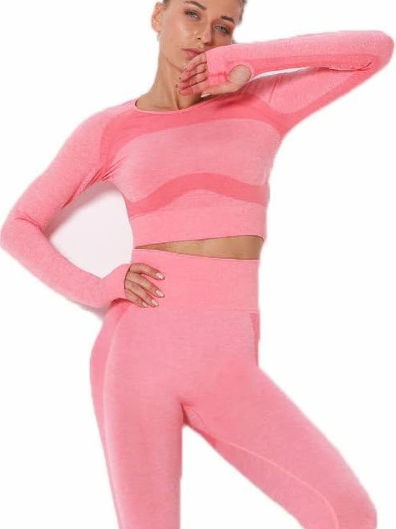 Model wearing a seamless long sleeve yoga set in pink with cut-out details and color block design.