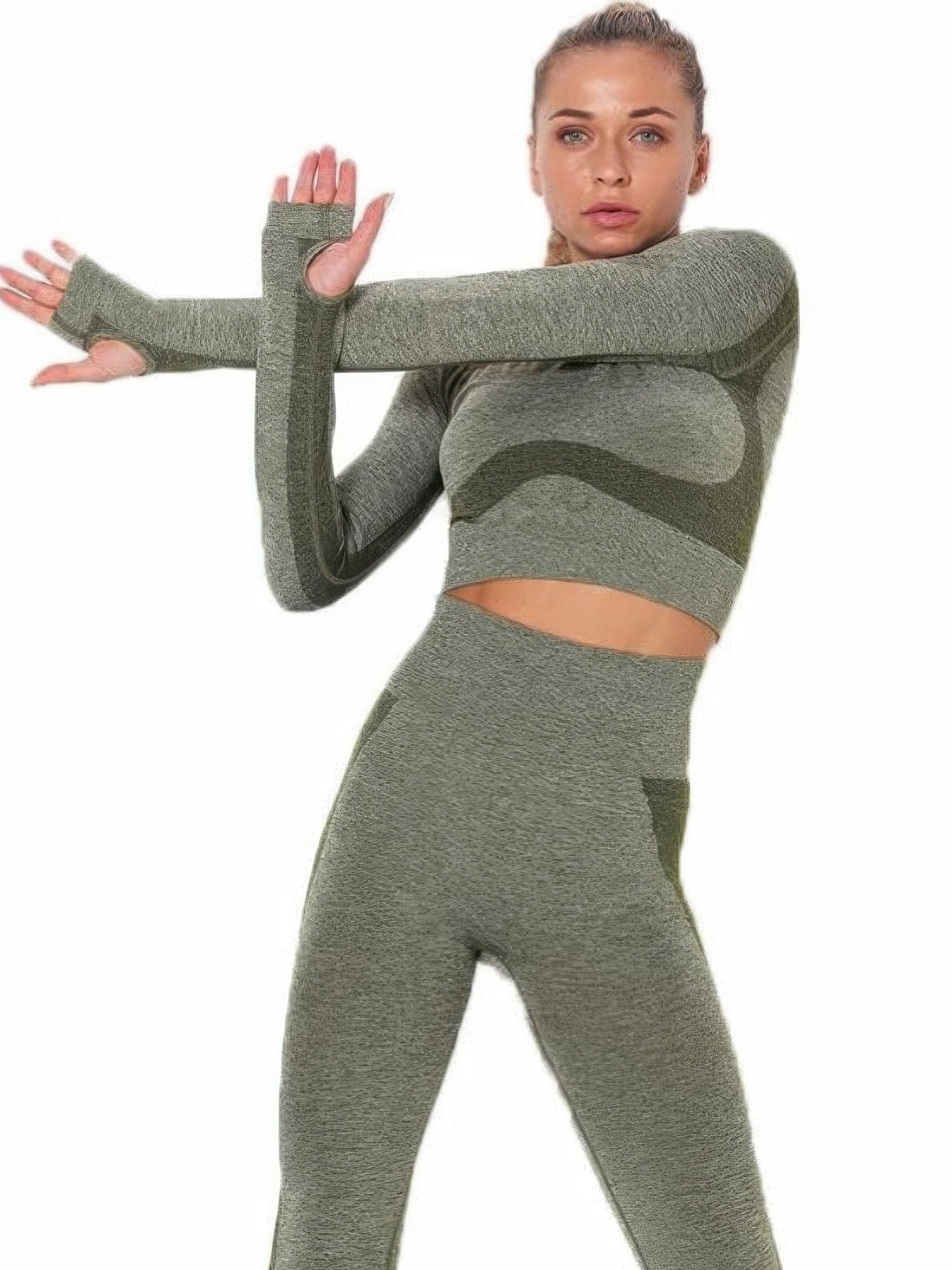 Model demonstrating seamless long sleeve yoga set with cut-out accents and high-waisted leggings in green.