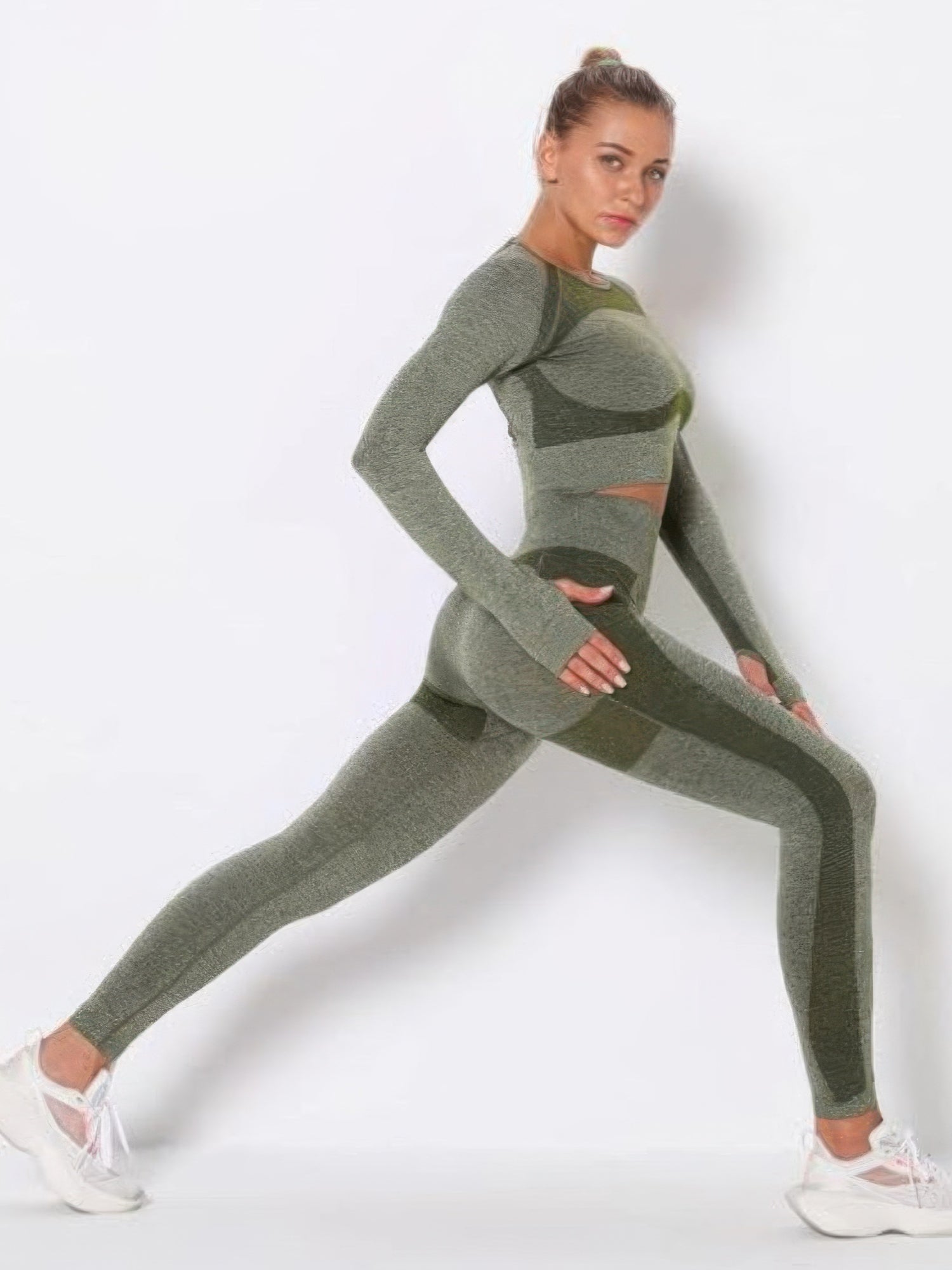 Model showcasing the seamless long sleeve yoga set in green, demonstrating a stretch pose.