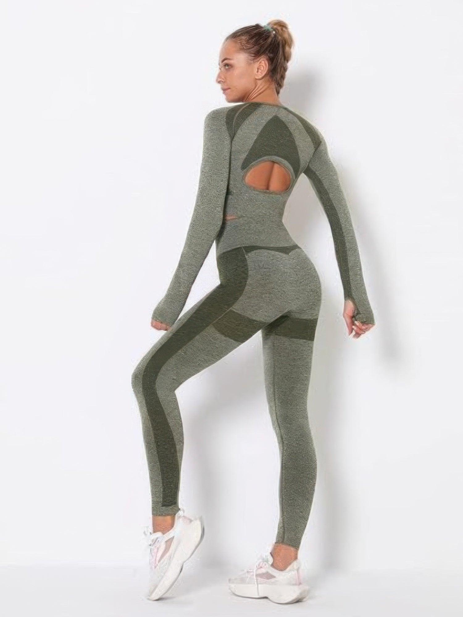 Model showcasing a seamless long sleeve yoga set in green, featuring a crop top with cut-out accents and high-waisted leggings.