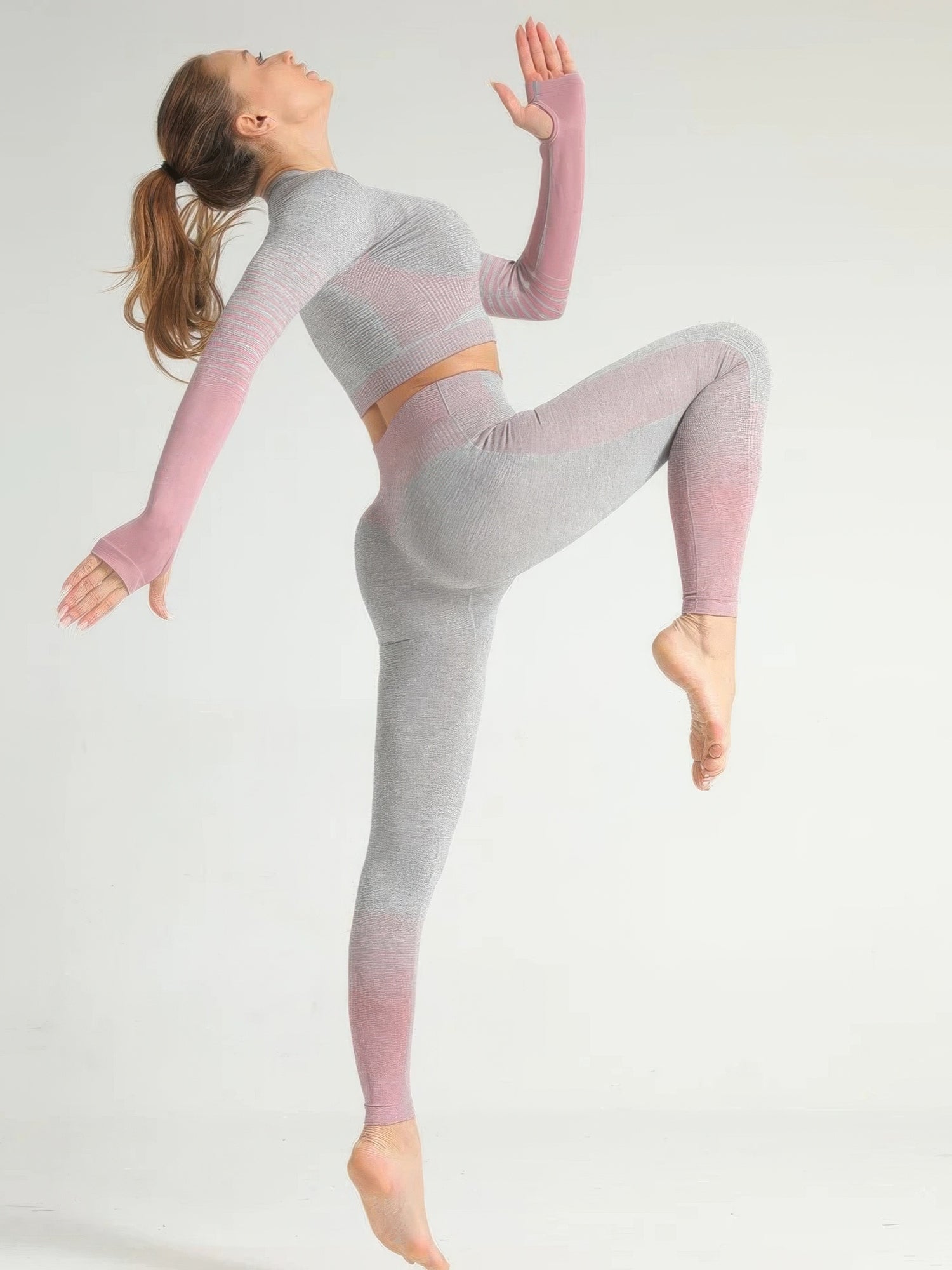 Woman in a stripe seamless yoga set performing a dance pose, showcasing comfort and flexibility.