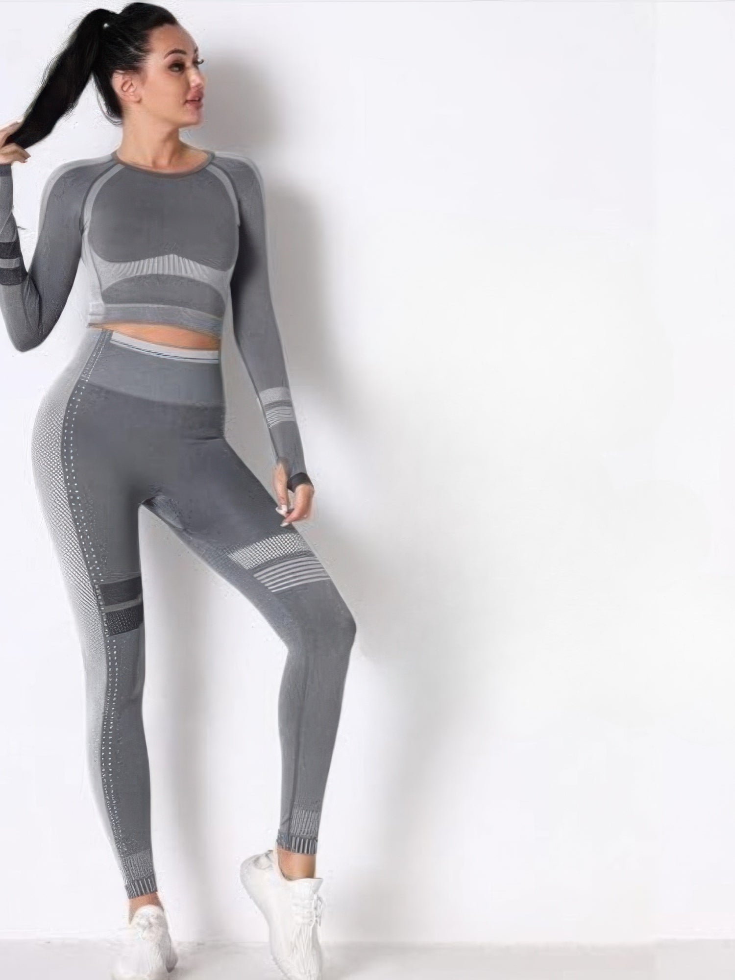 Seamless long sleeve solid yoga set displayed with a model in gray showcasing its body-hugging fit and style.