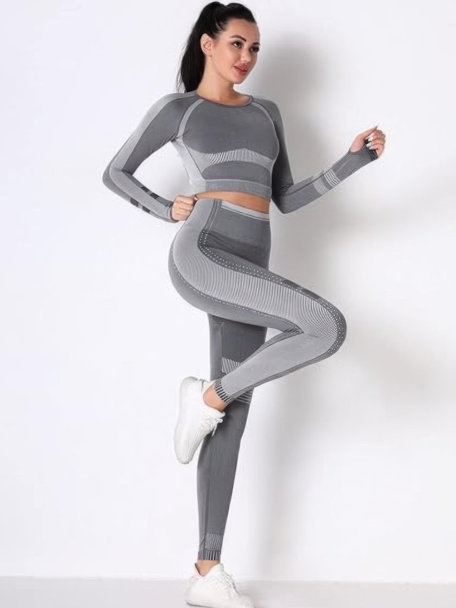 Seamless yoga set featuring a long sleeve crop top and high-waisted leggings in grey, perfect for workouts and everyday wear.