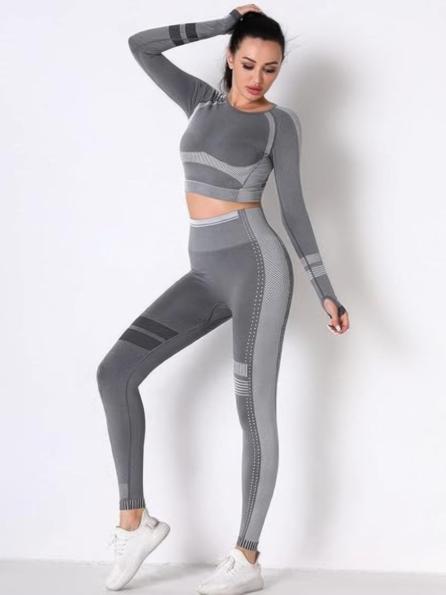 Seamless yoga set featuring long sleeve crop top and high-waisted leggings in gray, designed for comfort and flexibility.