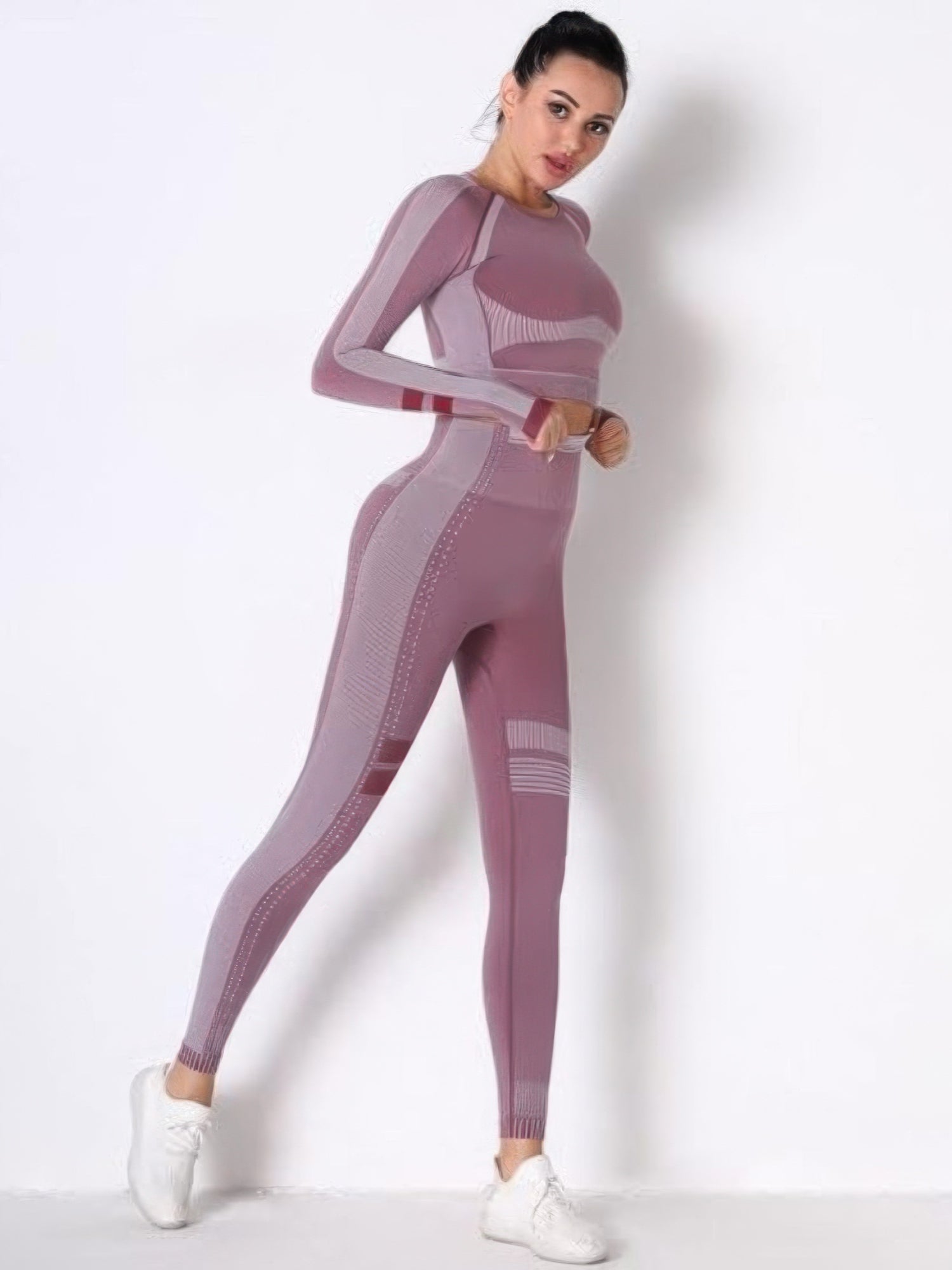 Model wearing a seamless long sleeve yoga set in mauve, showcasing the fitted long sleeve crop top and high-waisted leggings.