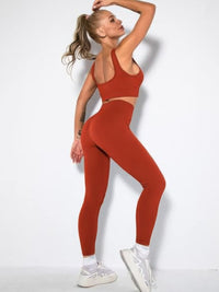 Ribbed two piece activewear set in rust color featuring sleeveless crop top and high-waisted leggings.