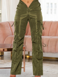 V Cut Cargo Pants in olive green with a V-shaped waistline and wide-leg fit, styled in a modern setting.