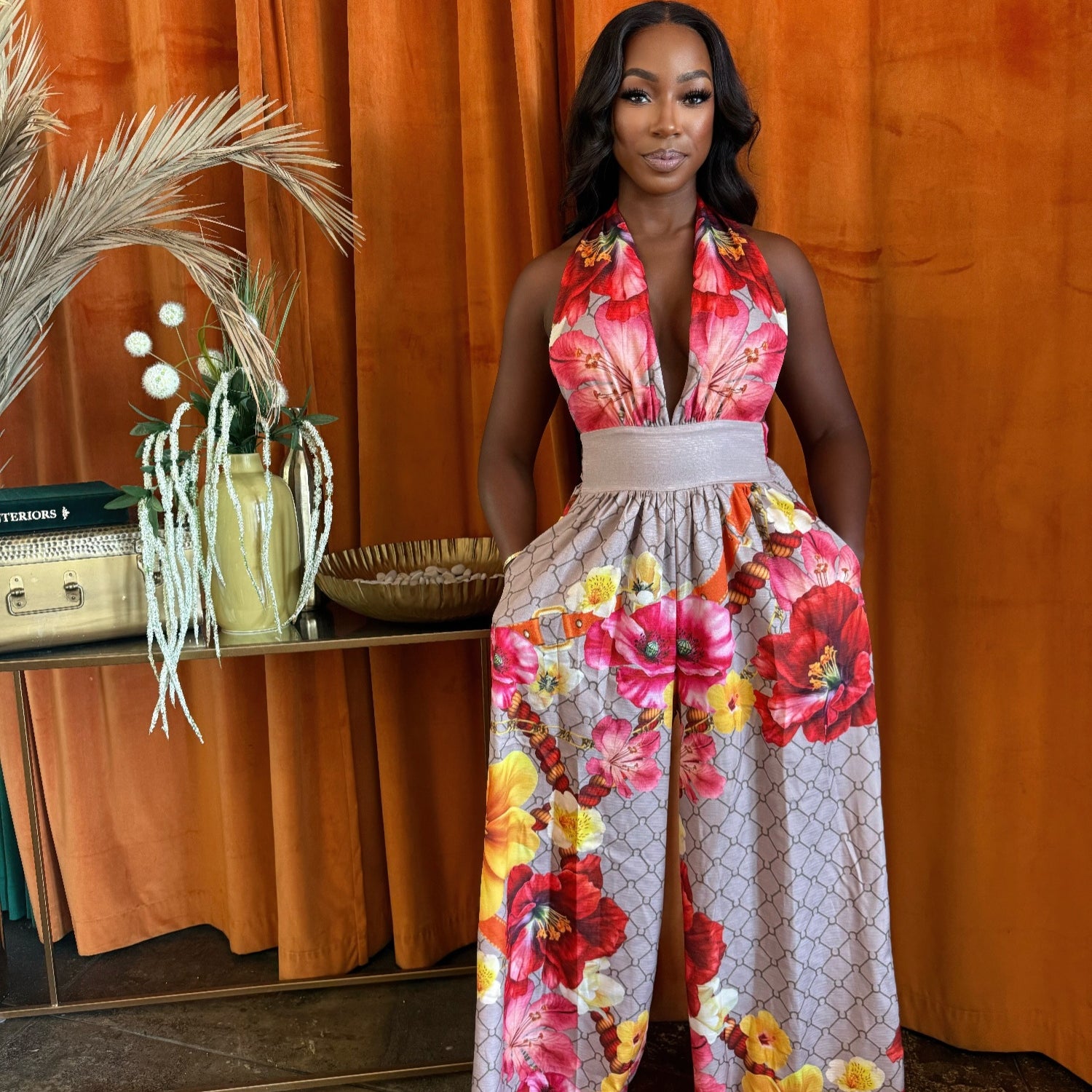 Model wearing a Paradise Bloom Jumpsuit, a resort style jumpsuit with floral print and wide-leg silhouette.