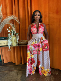 Model wearing a Paradise Bloom Jumpsuit, a resort style jumpsuit with floral print and wide-leg silhouette.