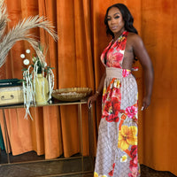 Model wearing the Paradise Bloom Jumpsuit, a resort style jumpsuit with floral patterns and a plunging neckline.