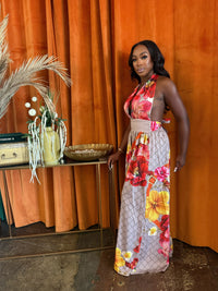 Model wearing the Paradise Bloom Jumpsuit, a resort style jumpsuit with floral patterns and a plunging neckline.