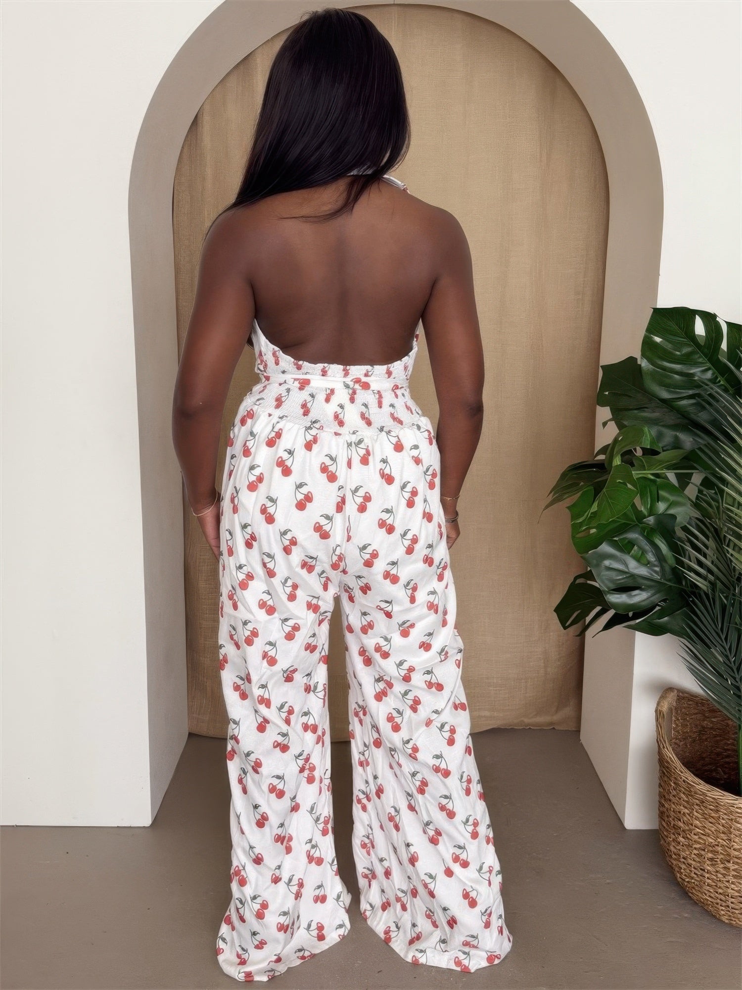 Back view of Cherry Print Halter Wide-Leg Jumpsuit showcasing vibrant cherry print and dramatic wide-leg design.