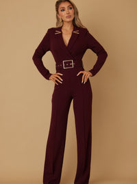 Stylish woman wearing a blazer jumpsuit for women with belt and long sleeves in a burgundy color.