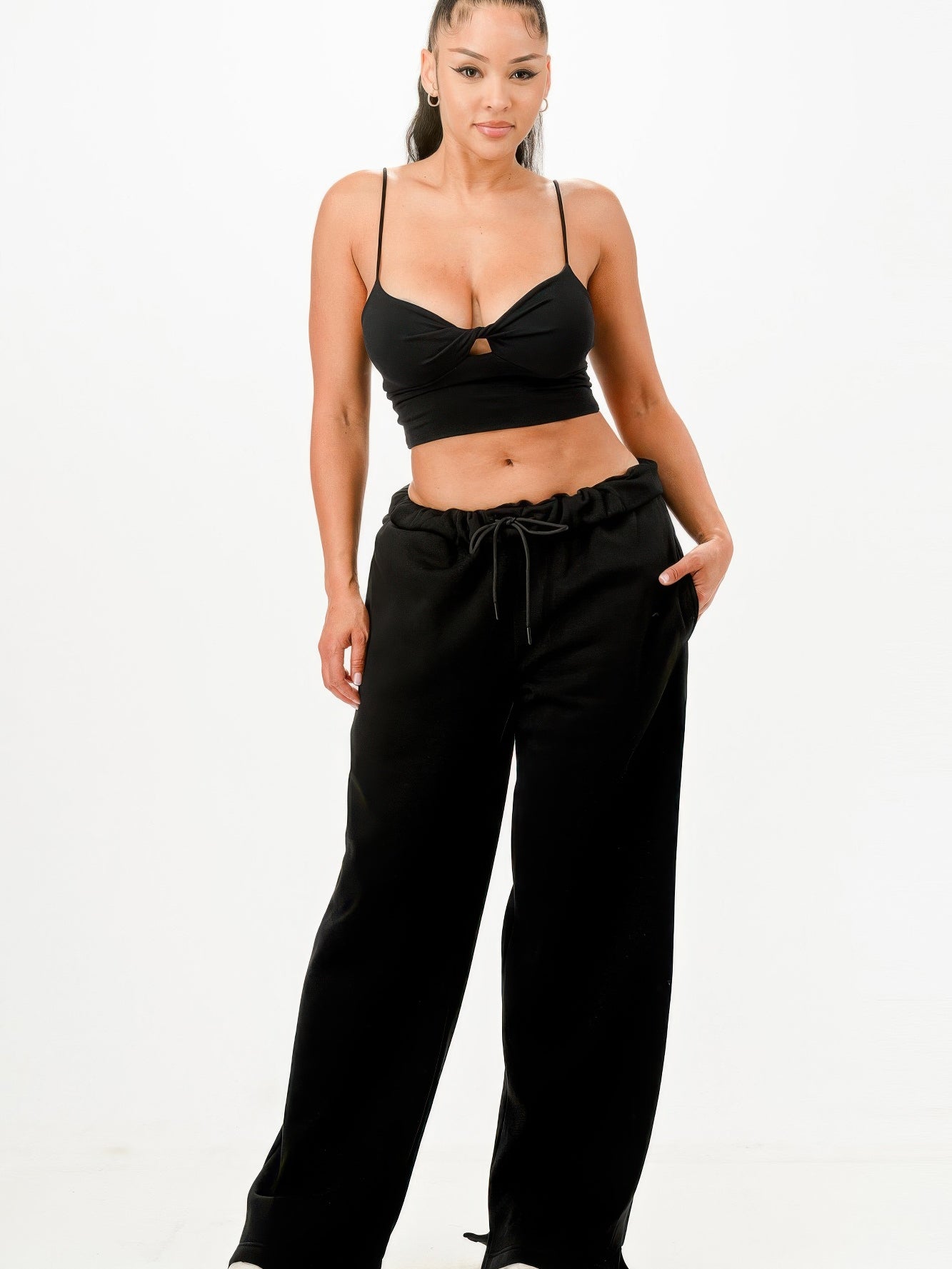 Woman wearing Baggy Sweatpants Streetwear in black, styled with a cropped top, showcasing a trendy and comfortable look.