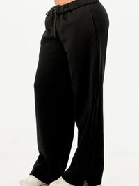 Baggy Sweatpants Streetwear in black with a drawstring waistband, styled casually with sneakers.