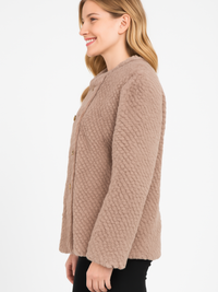 Model wearing a side view of the Textured Double-Breasted Faux Shearling Jacket in a warm beige tone.