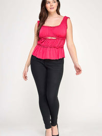 Model wearing a Plus Size Ruffled Tank With Cut Out, featuring ruffles and a cut-out detail, paired with black jeans.