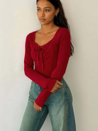 Long Sleeve Scrunch Bow Top in red with gathered front and bow accent, styled with blue jeans.