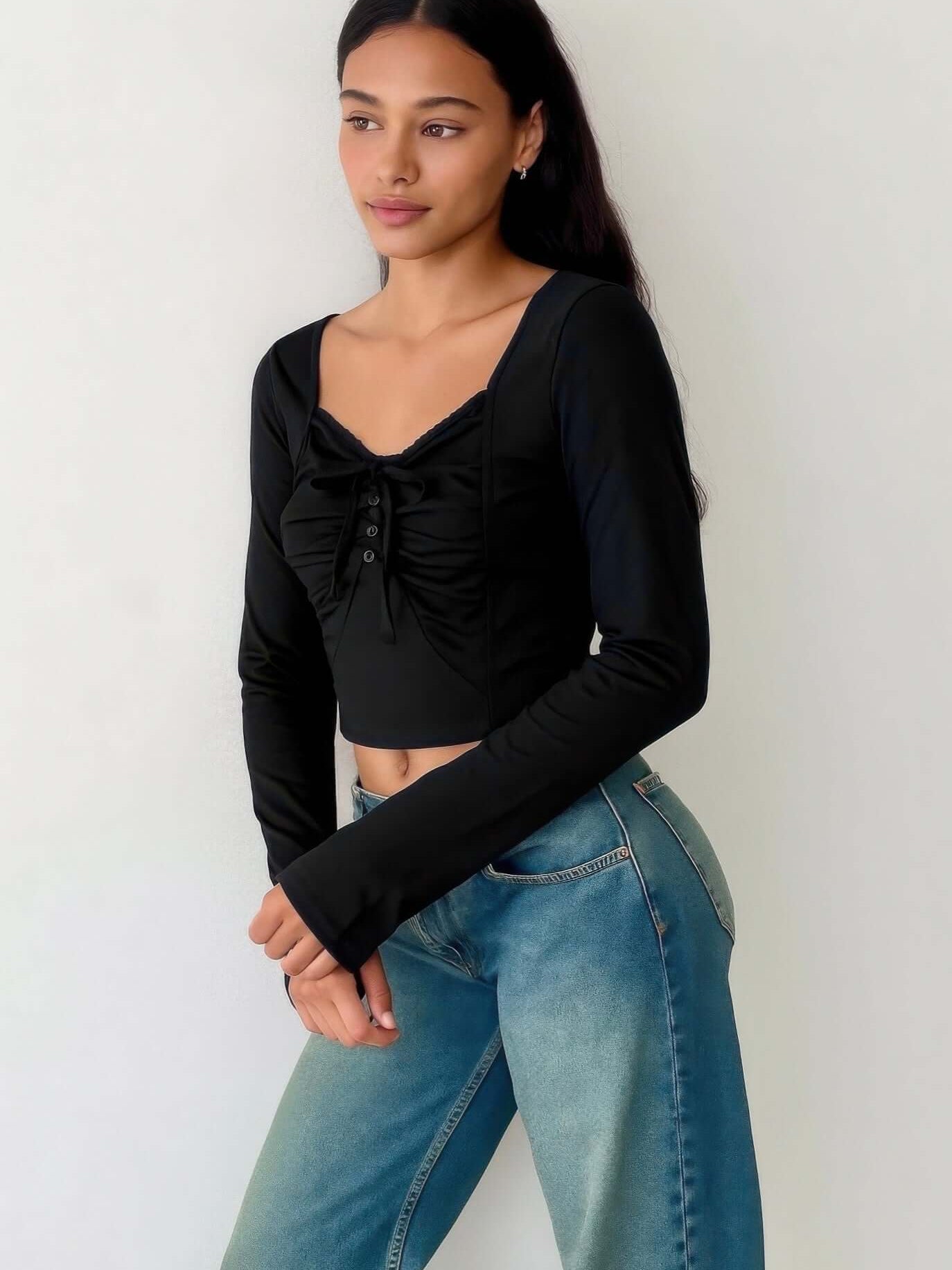 Long Sleeve Scrunch Bow Top worn by a model, featuring a gathered front and stylish bow accent.