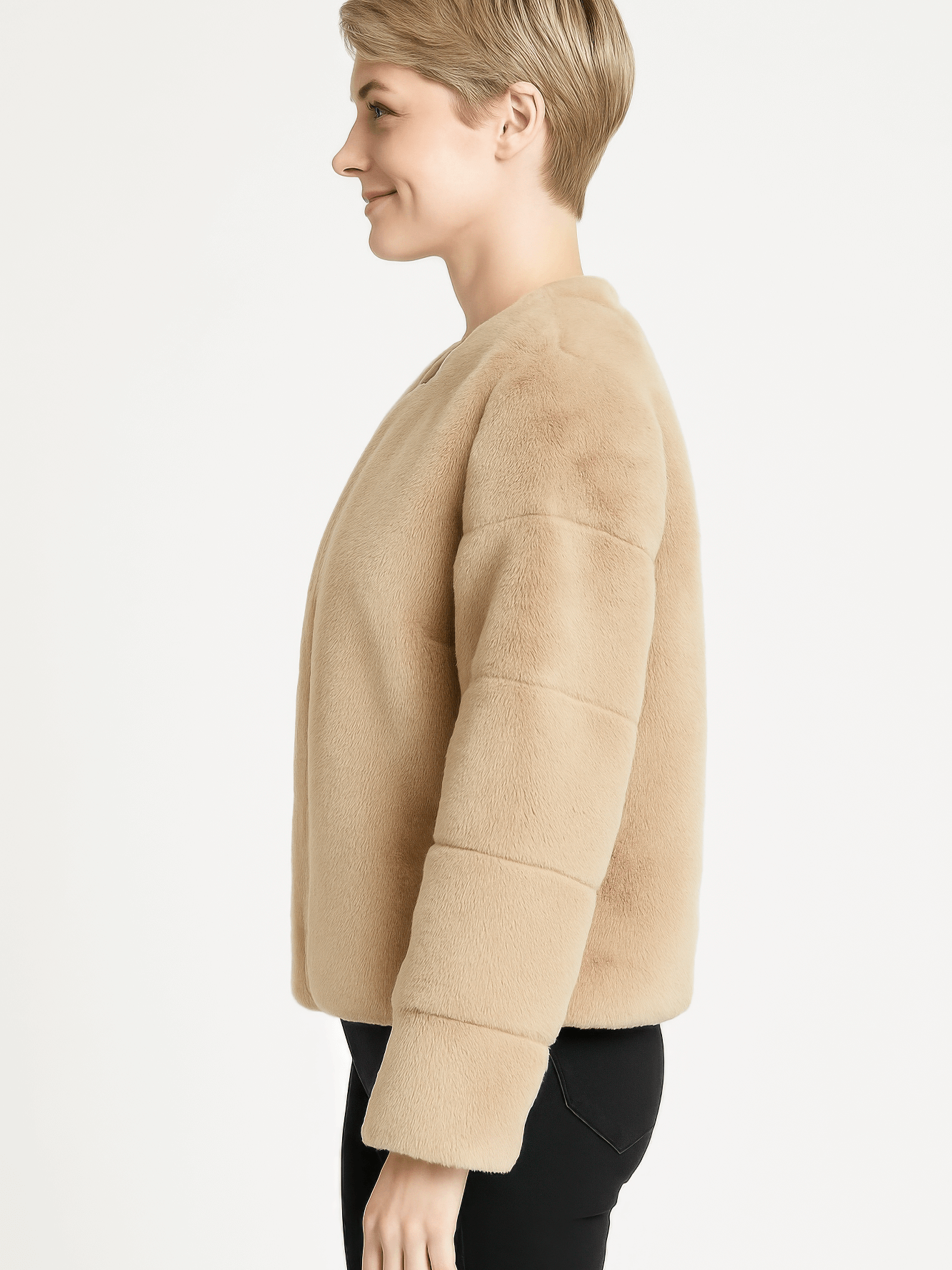 Side view of a woman wearing a beige faux fur jacket, showcasing its plush design and modern fit.