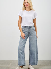 Model wearing High Rise Low Curve Barrel jeans with a white t-shirt and sneakers, showcasing a modern stylish look.