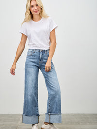 Model wearing Mid Rise Cuffed Jeans With Stretch, styled with a white t-shirt and casual sneakers.