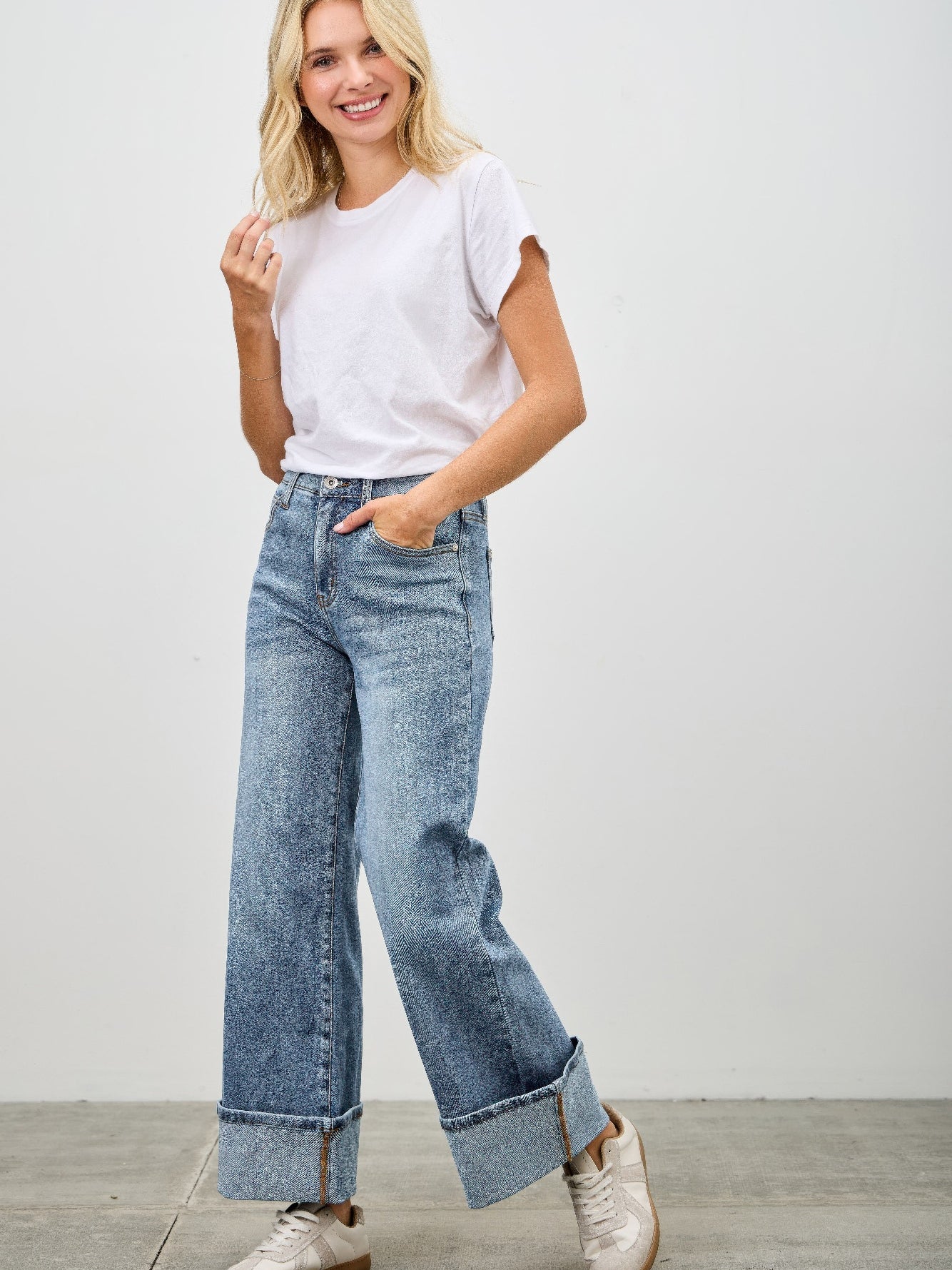 Mid Rise Cuffed Jeans With Stretch modeled with a casual white tee and stylish sneakers.