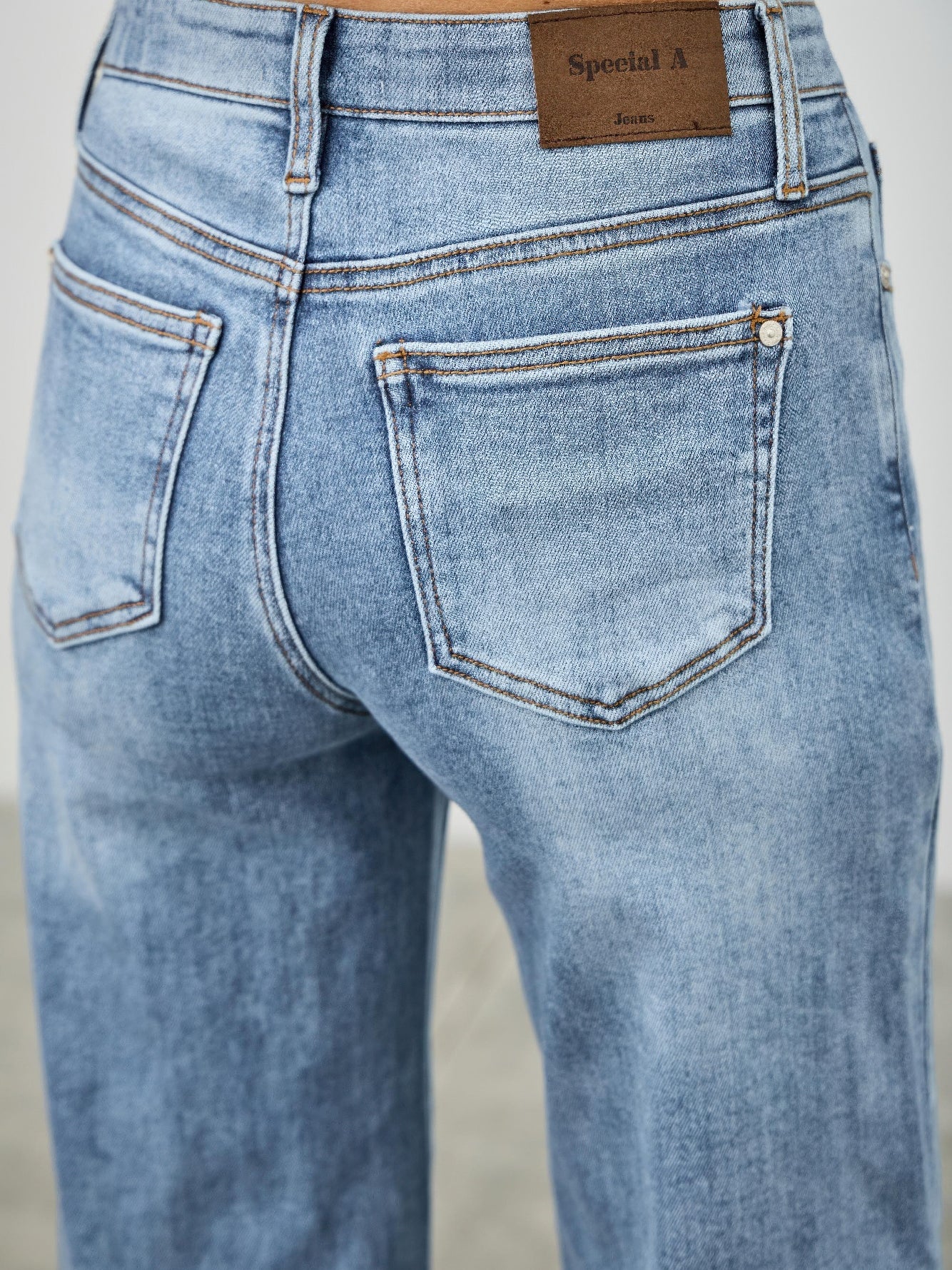 Mid Rise Cuffed Jeans With Stretch showing back view and cuffed hem in a soft blue wash.