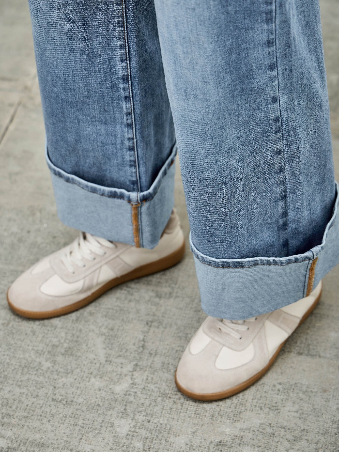 Mid Rise Cuffed Jeans With Stretch styled with white sneakers, showcasing a casual and polished look.