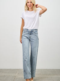 Model wearing Mid Rise Straight With Piping jeans with a white t-shirt and heels, showcasing refined denim style.