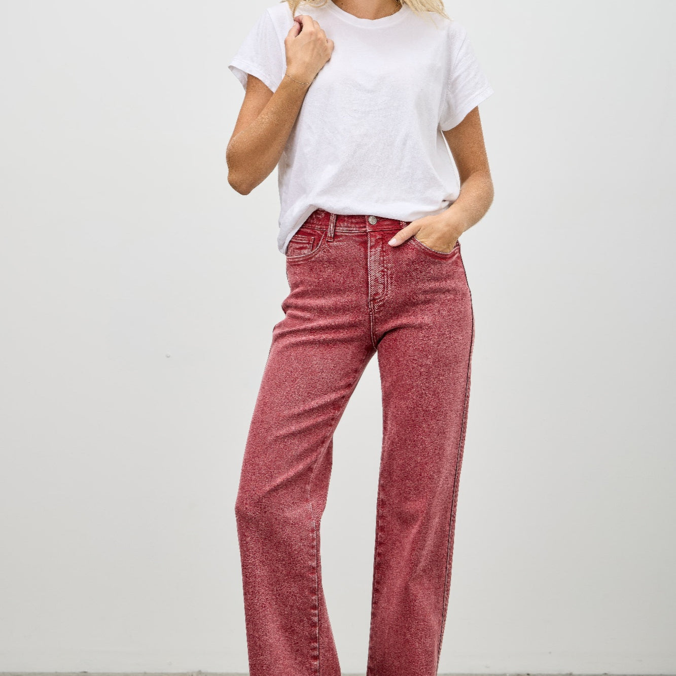 Model wearing High Rise Slim Wide Straight jeans in red with a white t-shirt and stylish heels.