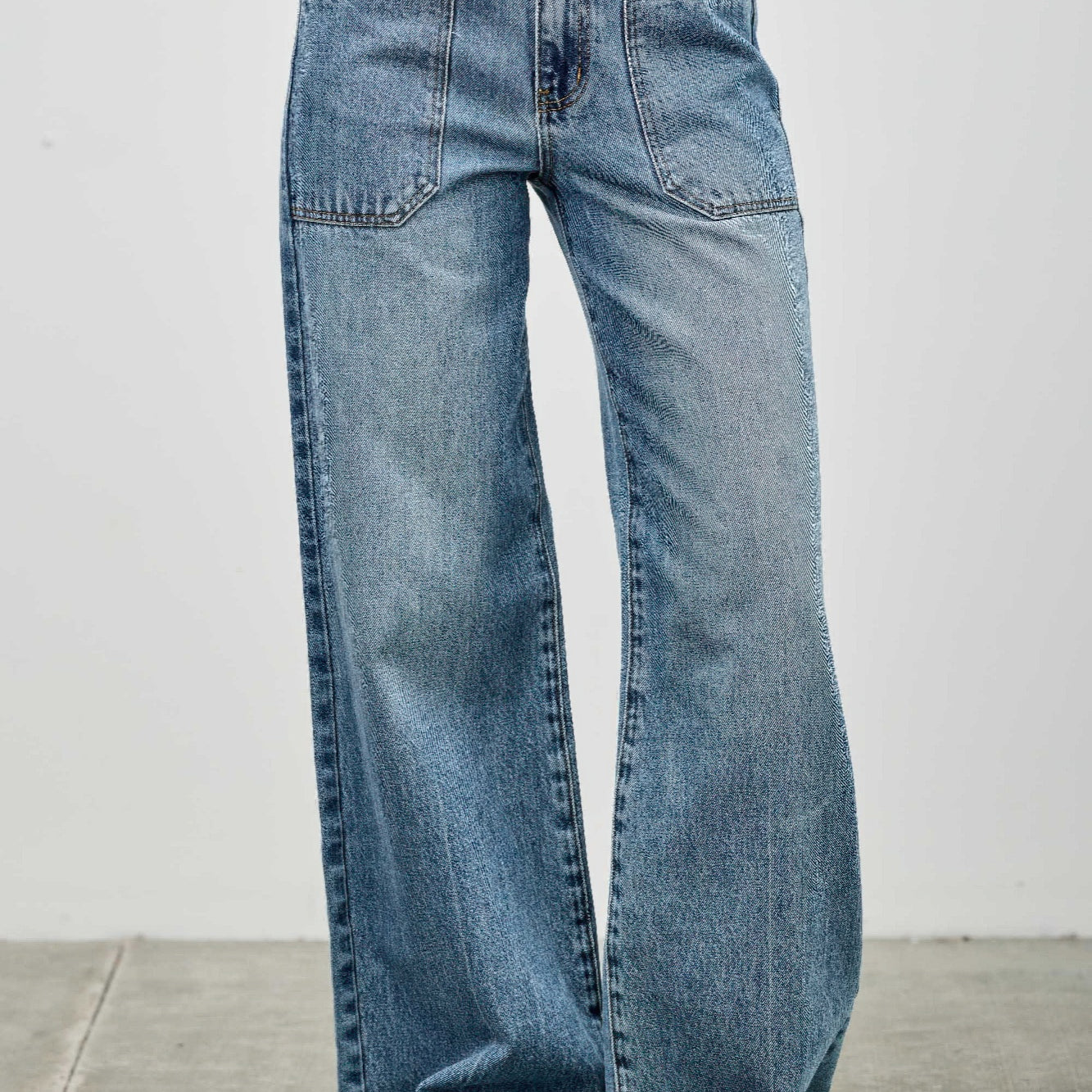 High Rise Double Pocket Wide Leg jeans featuring patched front pockets and a wide leg silhouette.